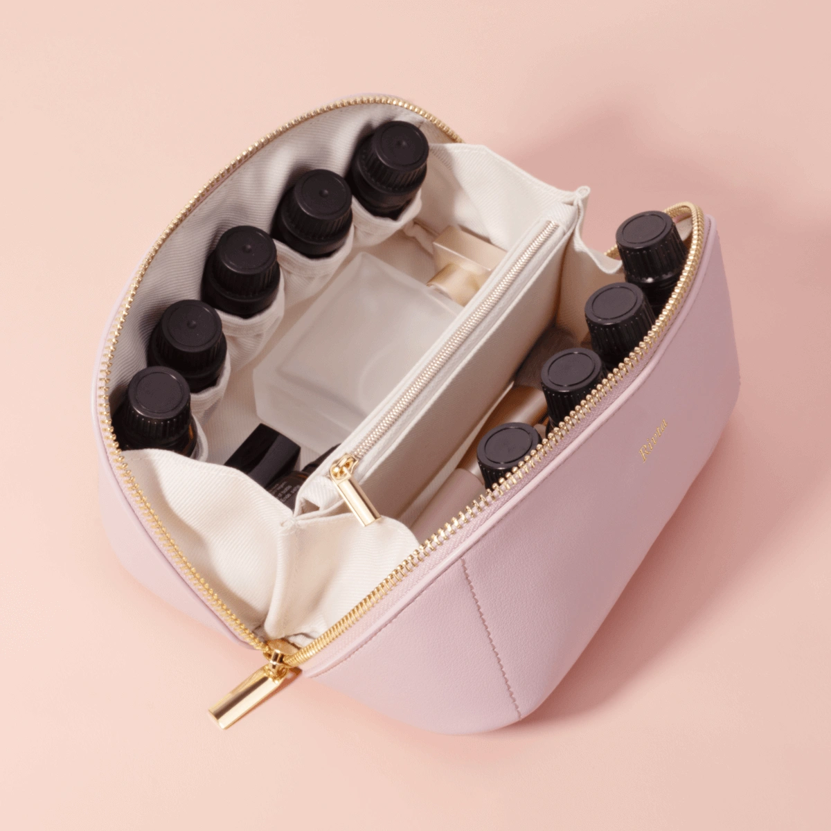 Open cosmetic pouch loaded with bottles and two zipper pulls