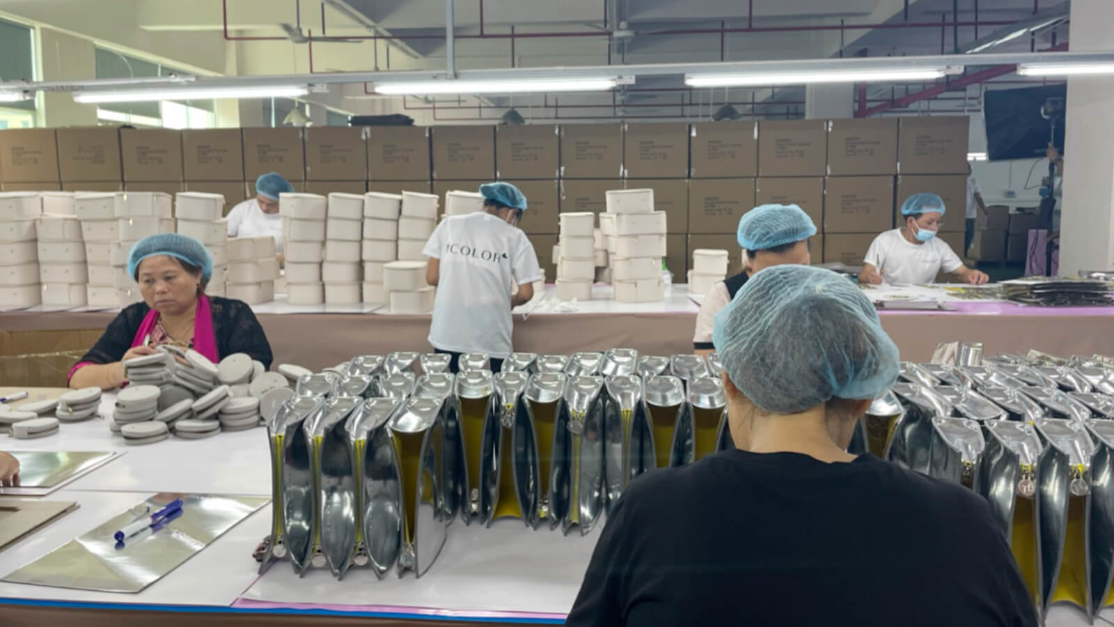 an iColor team member inspecting custom ring boxes at a manufacturing facility