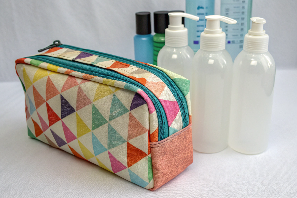 A makeup bag made from RPET fabric next to plastic bottles