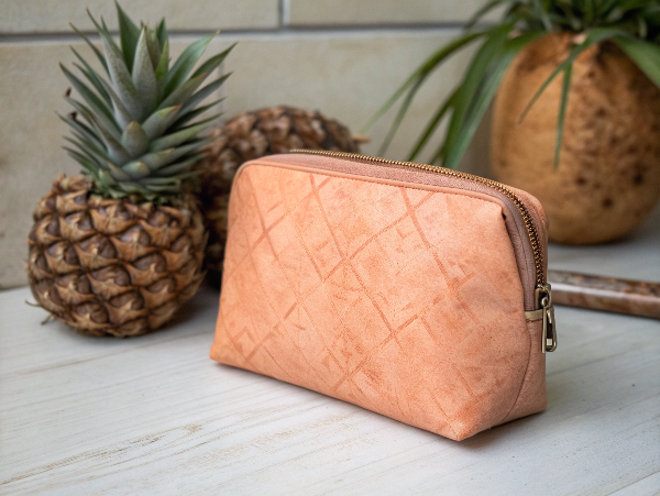 A unique cosmetic bag made from a textured, plant-based material like pineapple or apple leather