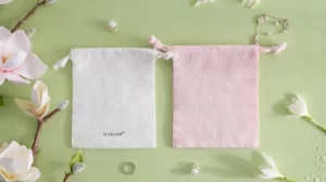 Bamboo fiber jewelry bags in white and pink, soft eco-friendly drawstring pouches for custom jewelry packaging.