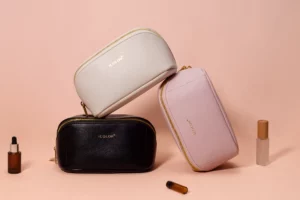 Custom leather jewelry and cosmetic bags in pink, white, and black by Icolor, featuring a sleek design with gold zippers, ideal for storing beauty and jewelry items.