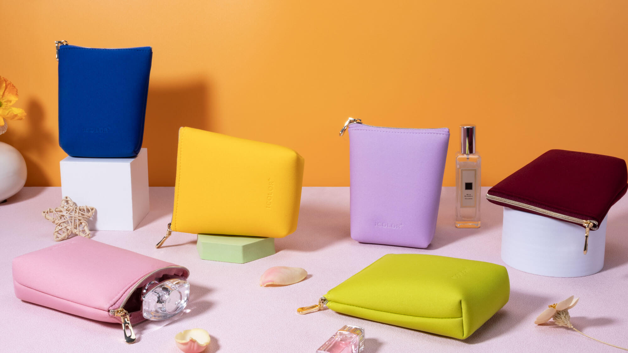 Sleek neoprene cosmetic cases in bright and neutral colors, one with a waterproof zipper