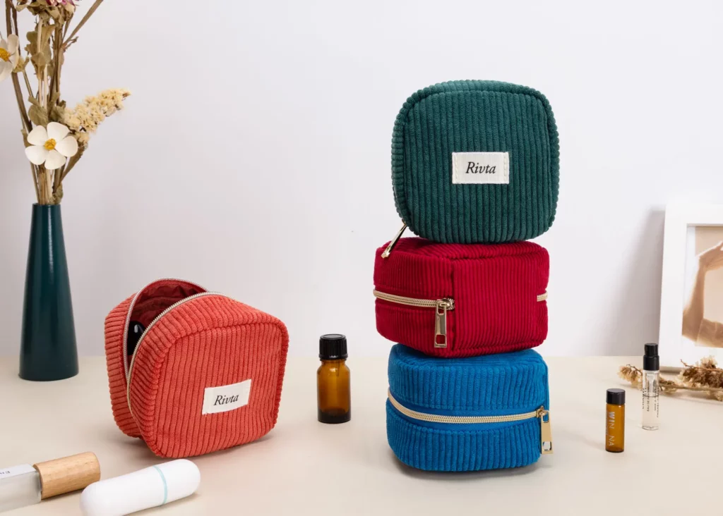 Colorful rPET corduroy essential oil storage bags in coral, green, red, and blue, displayed with small essential oil bottles on a clean studio background.