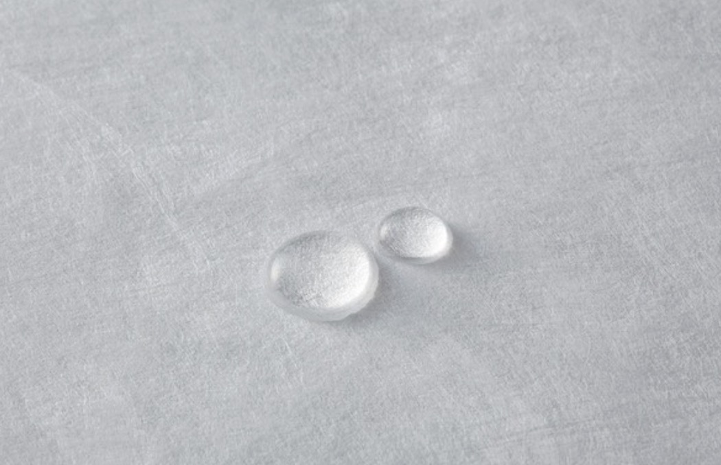 Water droplets sitting on the surface of a Tyvek tote bag