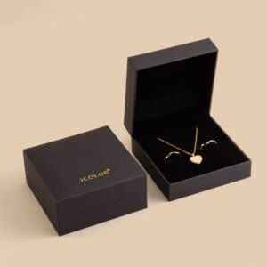 Black hinged paper jewelry box with velvet interior and jewelry
