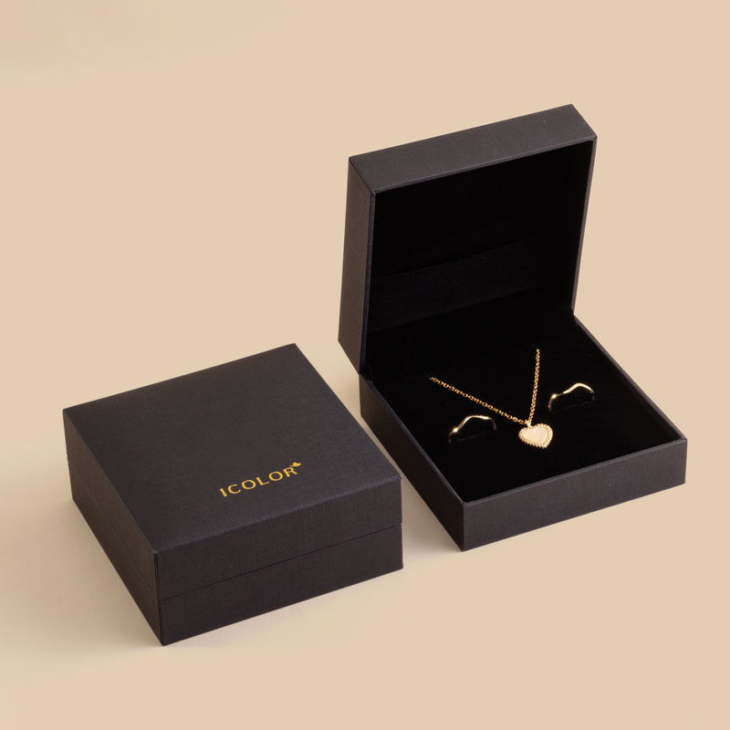 Black hinged paper jewelry box with velvet interior and jewelry