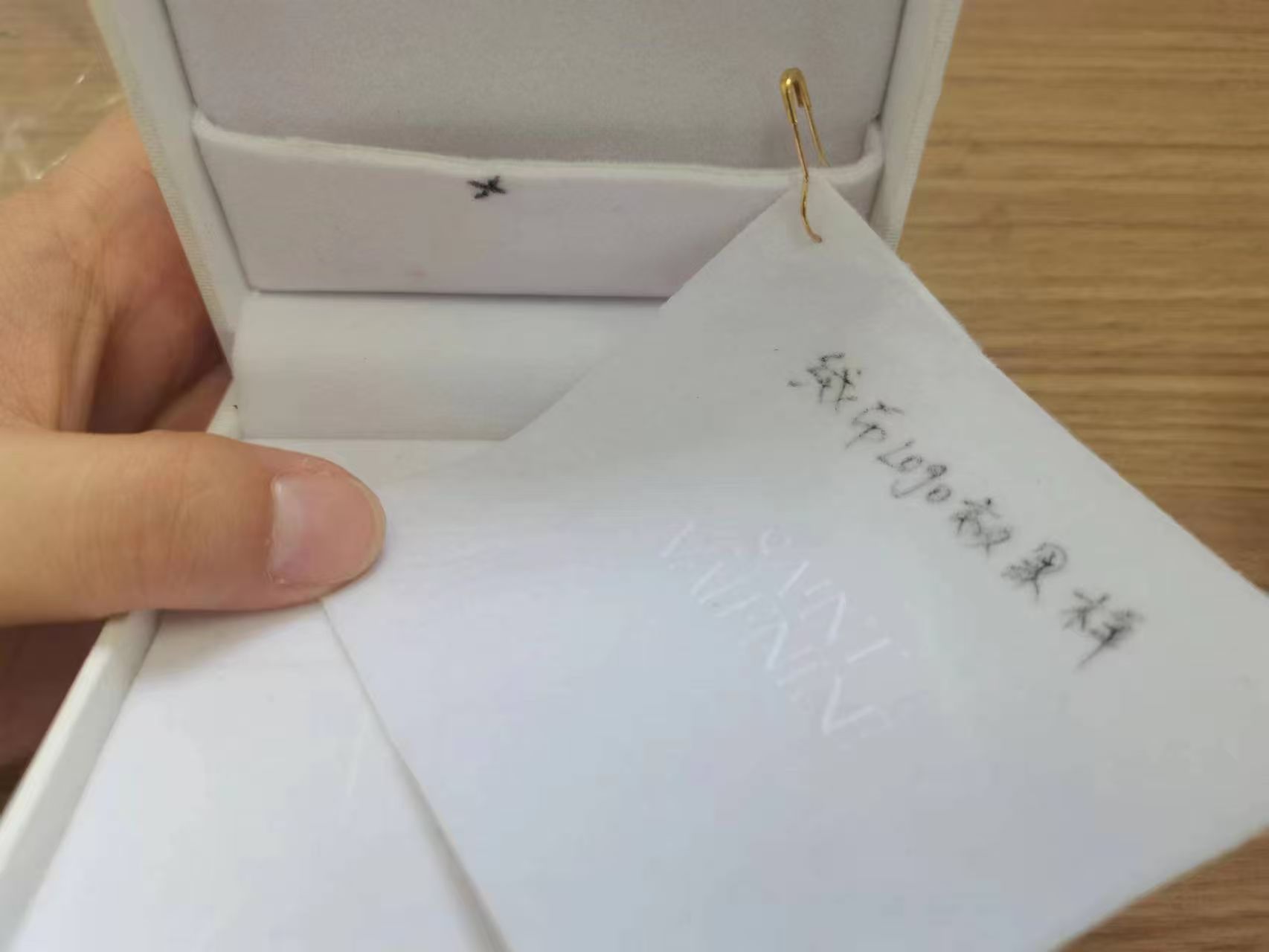 Sample-stage velvet logo rubbing and transfer inside a hinged jewelry box